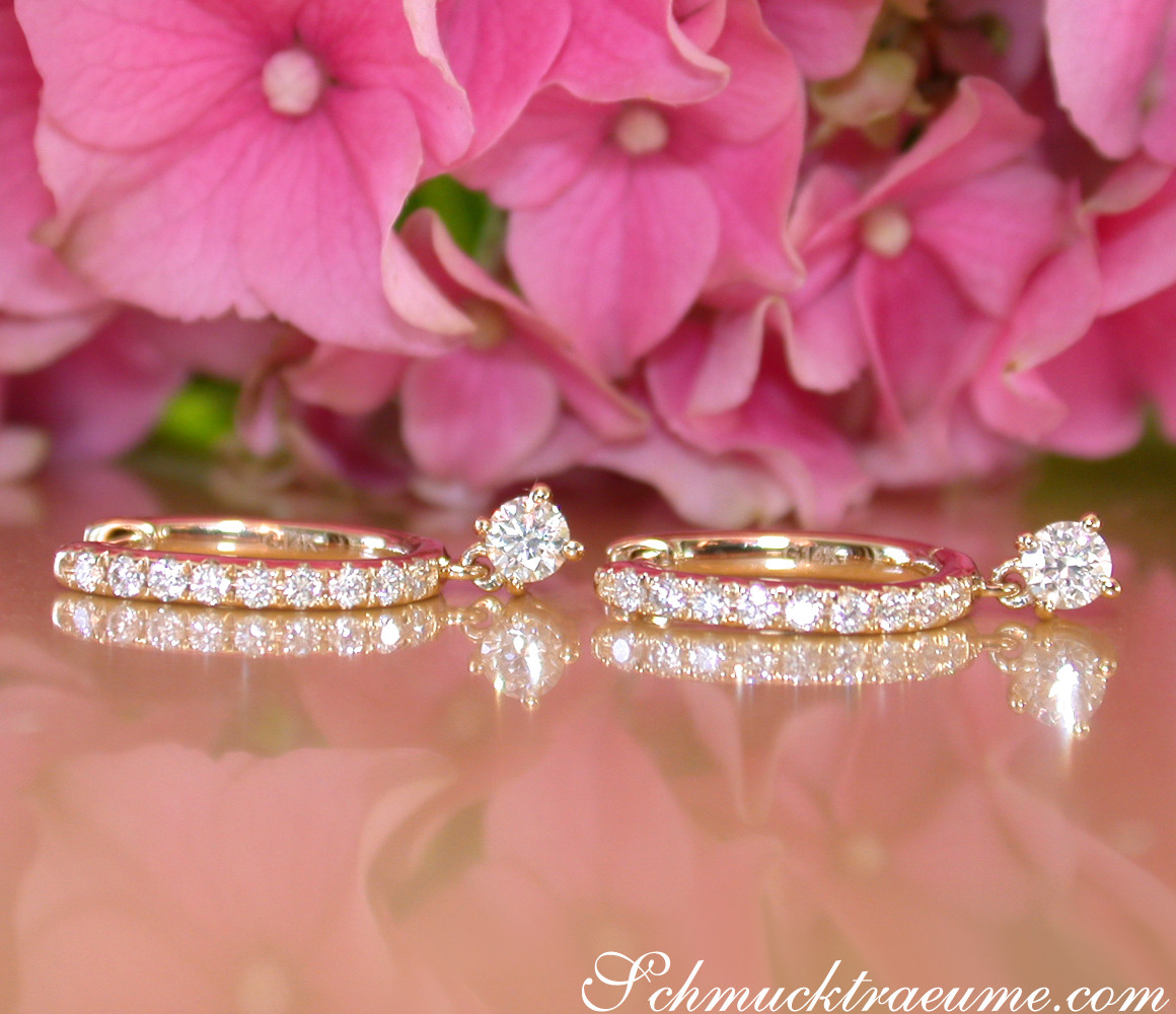 Goldene Creolen mit Swinging Diamonds, Detailaufnahme mit Blütenhintergrund