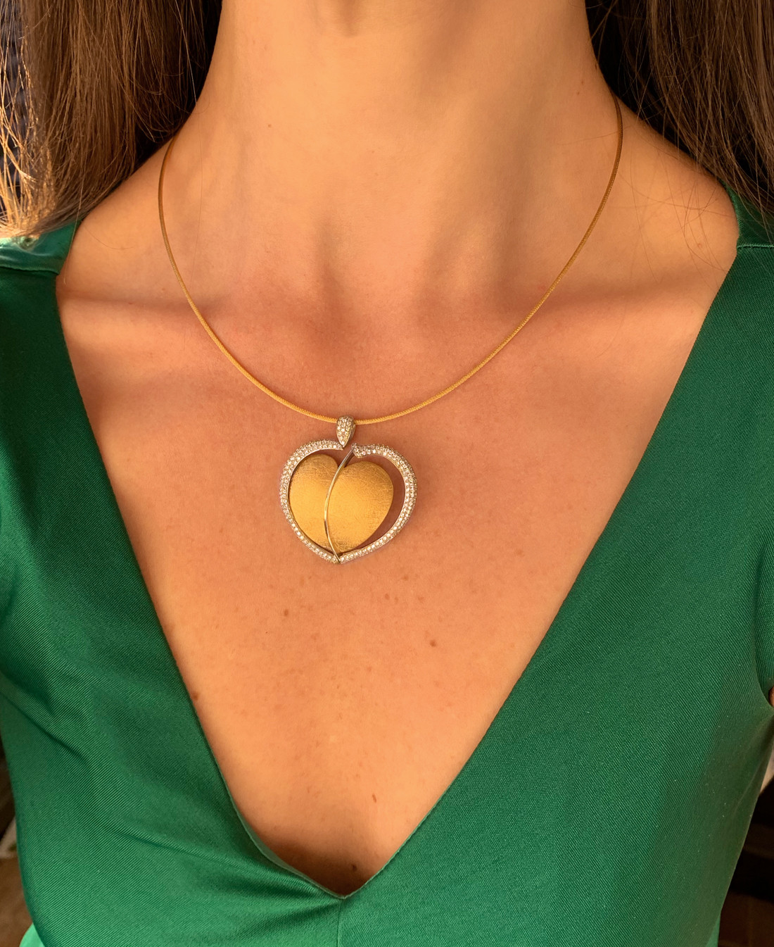 Goldenes Herz-Collier mit Brillanten auf grüner Bluse, Halsansicht