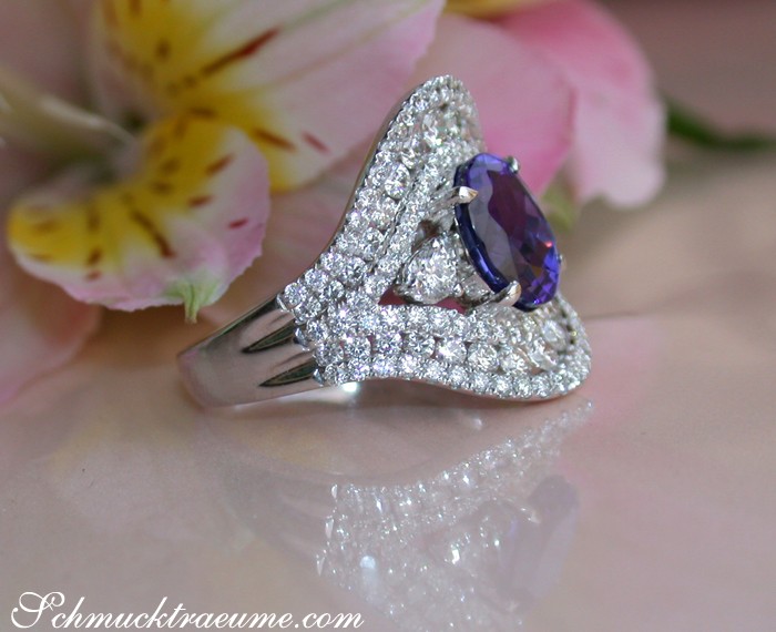 Weißgoldring mit Tansanit und Brillanten, Detailaufnahme, sanfte Formen, Blumen im Hintergrund