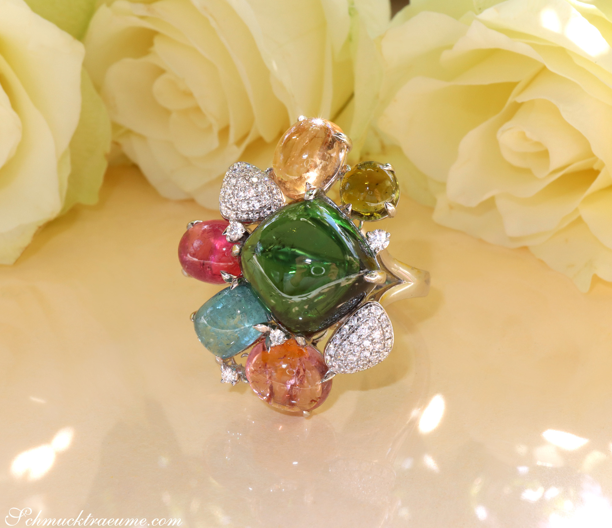 Weißgold-Ring mit Multicolor Turmalinen und Diamanten, Detailaufnahme, Rosen im Hintergrund.