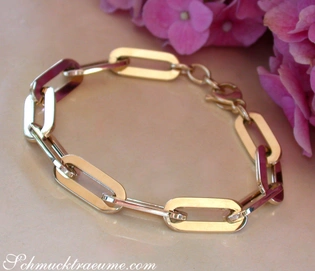 Goldenes Paperclip-Armband in Gelbgold 585 mit langen, klaren Gliedern auf rosafarbenem Hintergrund.