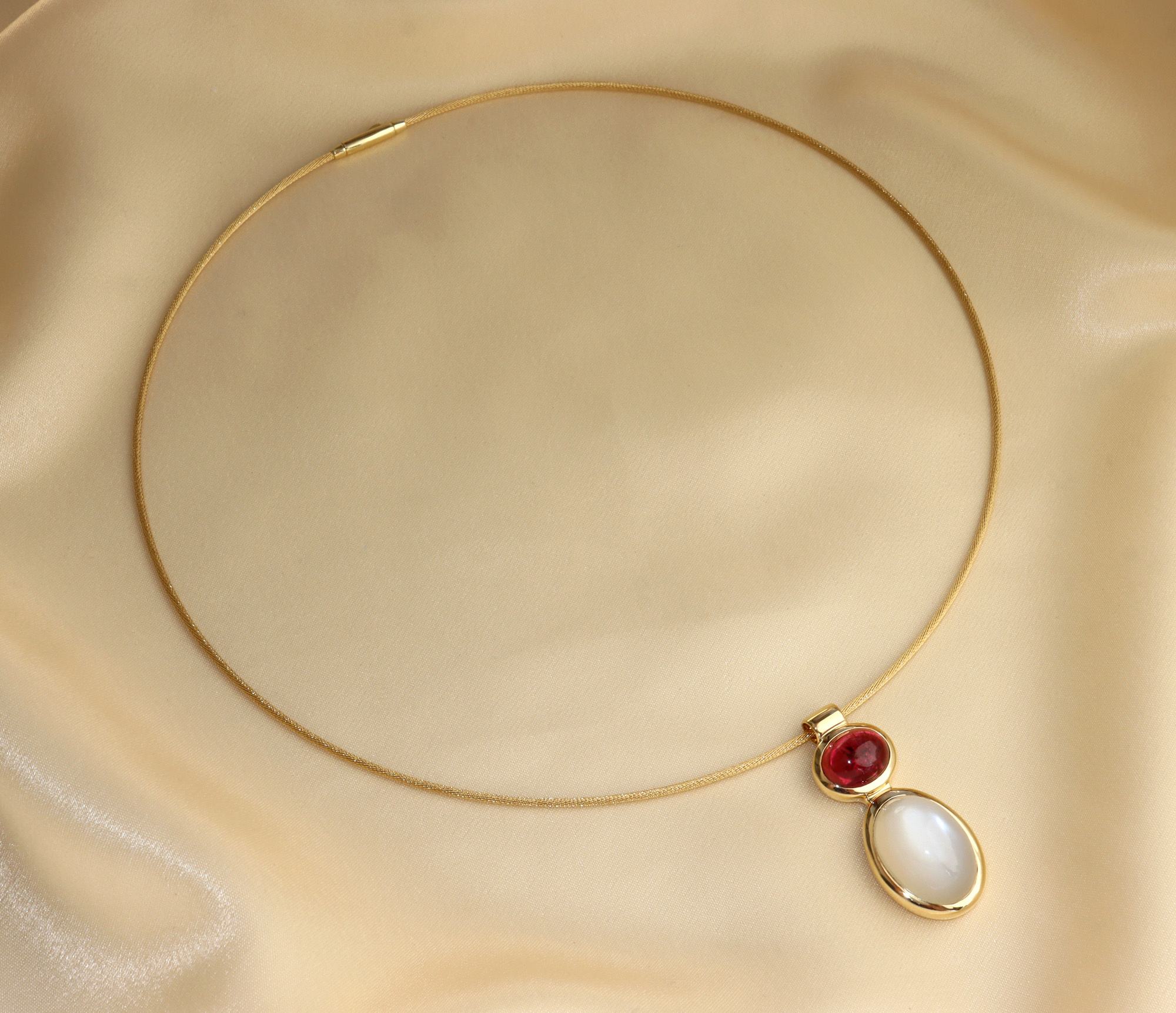 Goldene Halskette mit Rubellit und Mondstein, Detailaufnahme, sanfte Linien, elegant.
