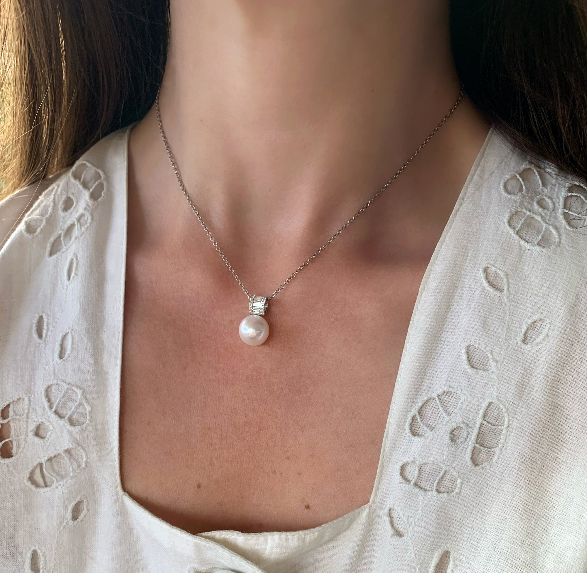 Perlenanhänger mit Baguette-Diamanten auf Halskette, elegant getragen.