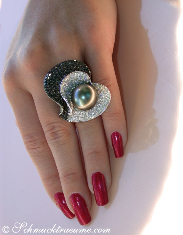 Hand mit spektakulärem Tahitiperlen-Ring, 15 mm, schwarze Diamanten, weiße Brillanten, dunkler Hintergrund