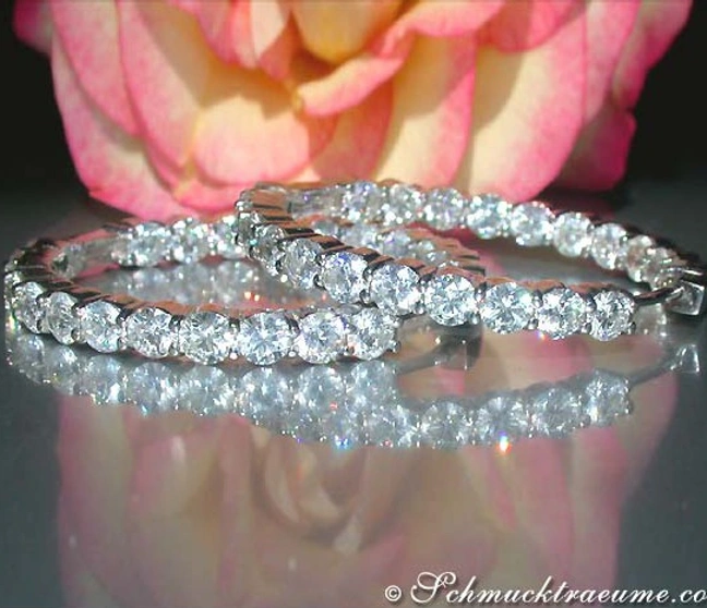 Strahlende Diamantcreolen auf Rosenhintergrund Strahlende Diamantcreolen auf Rosenhintergrund