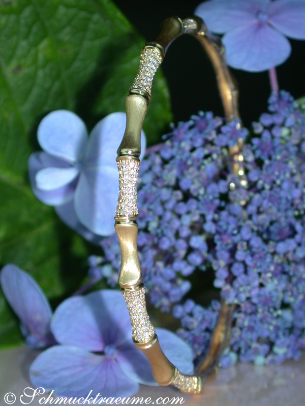 Diamantbambus-Armreif aus Gelbgold 585, Detailaufnahme mit blauen Hortensienblüten im Hintergrund