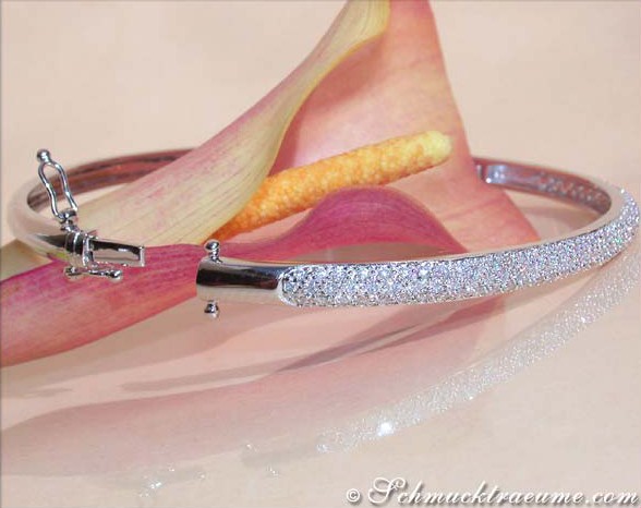 Schimmernder Diamant-Armreif in Weißgold 585, detailreich, elegant, mit Blüte im Hintergrund