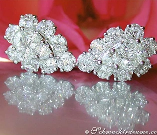 Diamant-Tropfen-Ohrstecker im Weißgold, detailliert mit funkelnden Brillanten, auf rosa Hintergrund.