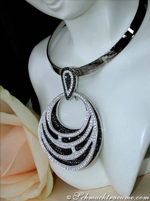 Silberner Anhänger mit schwarzen und weißen Diamanten auf Halsform, umgeben von Blüte