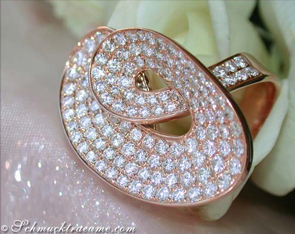 Extravagantes Brillantenring-Design in Roségold 750, Detailaufnahme des funkelnden Micropavé mit Blumen im Hintergrund.