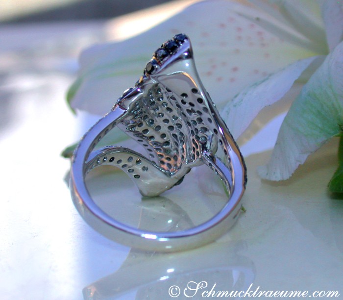 Schwarz-weiß-brauner Brillant-Ring auf Blüte, Detailaufnahme, elegante Verarbeitung.