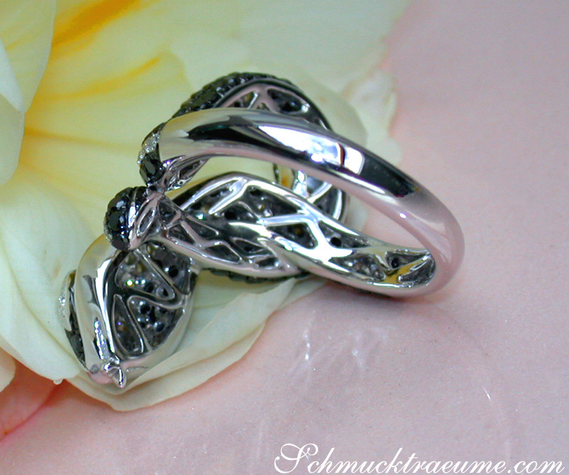 Schlangenring mit schwarzen Diamanten, detailreiches Design, glänzende Linien, auf Blume liegend.