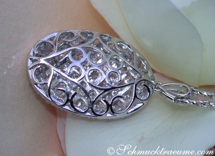 Weißgold-Brillanten-Anhänger mit feinen Verzierungen auf Rosenblätterhintergrund