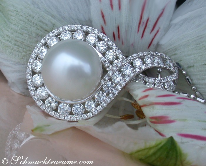 Schmuckdetail: Weiße Perle mit Diamant-Halo, Infinity-Schleife auf Blüte