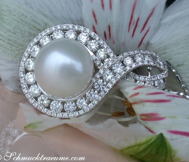 Schmuckdetail: Weiße Perle mit Diamant-Halo, Infinity-Schleife auf Blüte Schmuckdetail: Weiße Perle mit Diamant-Halo, Infinity-Schleife auf Blüte