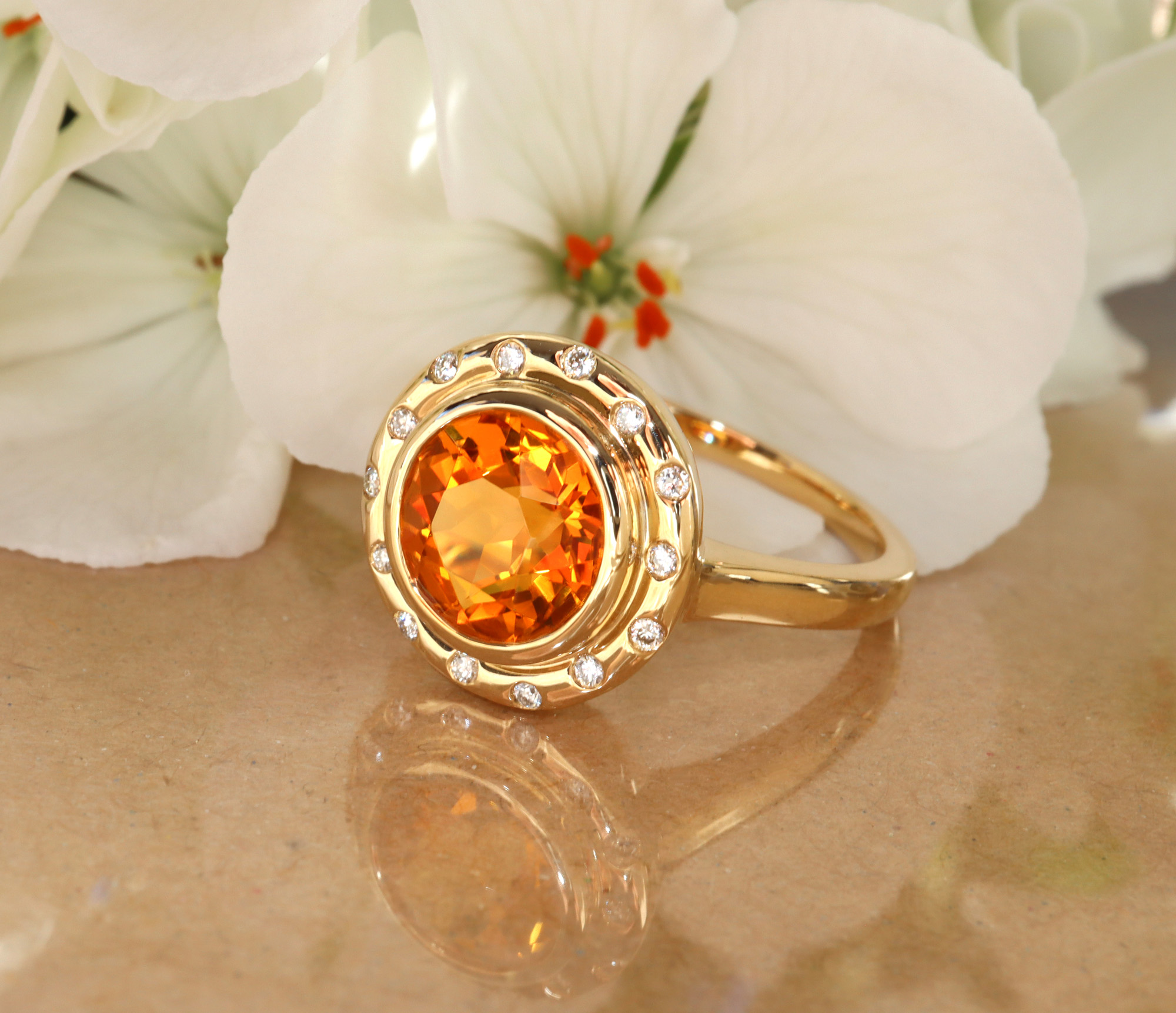 Goldener Citrin-Ring mit Diamanten, Blumenhintergrund.