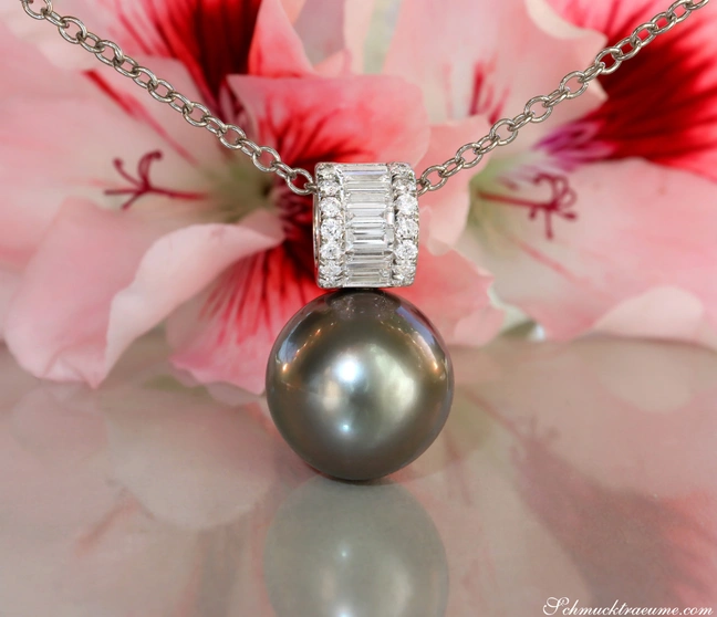 Tahitiperlen-Anhänger mit Baguette-Diamanten auf Silberkette, vor Blüte. Tahitiperlen-Anhänger mit Baguette-Diamanten auf Silberkette, vor Blüte.