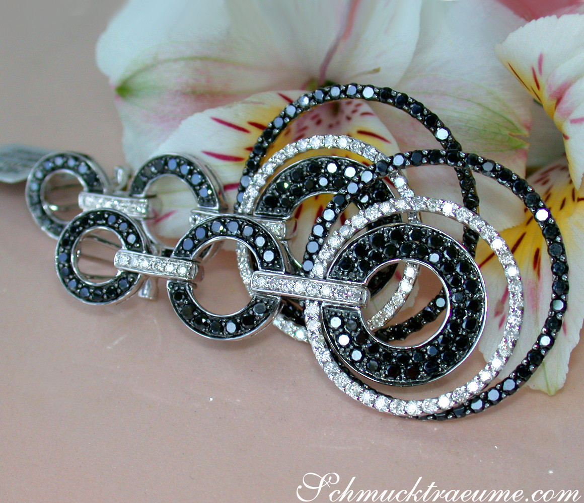 Schwarz-weiß-Diamant-Ohrringe mit Ringdetail auf Blume liegend