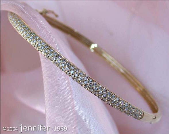 Gelbgold-Armreif mit Diamanten auf rosa Hintergrund