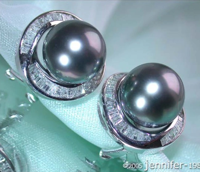 Schmuckstücke: Diamant-Tahitiperlen-Ohrringe auf silberner Unterlage Schmuckstücke: Diamant-Tahitiperlen-Ohrringe auf silberner Unterlage