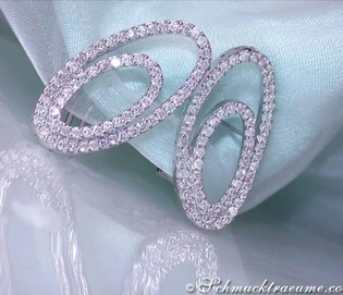 Diamant-Verzierte Ellipsen-Ohrstecker auf hellblauem Stoff, Detailaufnahme.