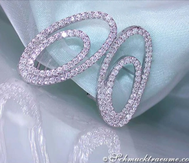 Diamant-Verzierte Ellipsen-Ohrstecker auf hellblauem Stoff, Detailaufnahme. Diamant-Verzierte Ellipsen-Ohrstecker auf hellblauem Stoff, Detailaufnahme.