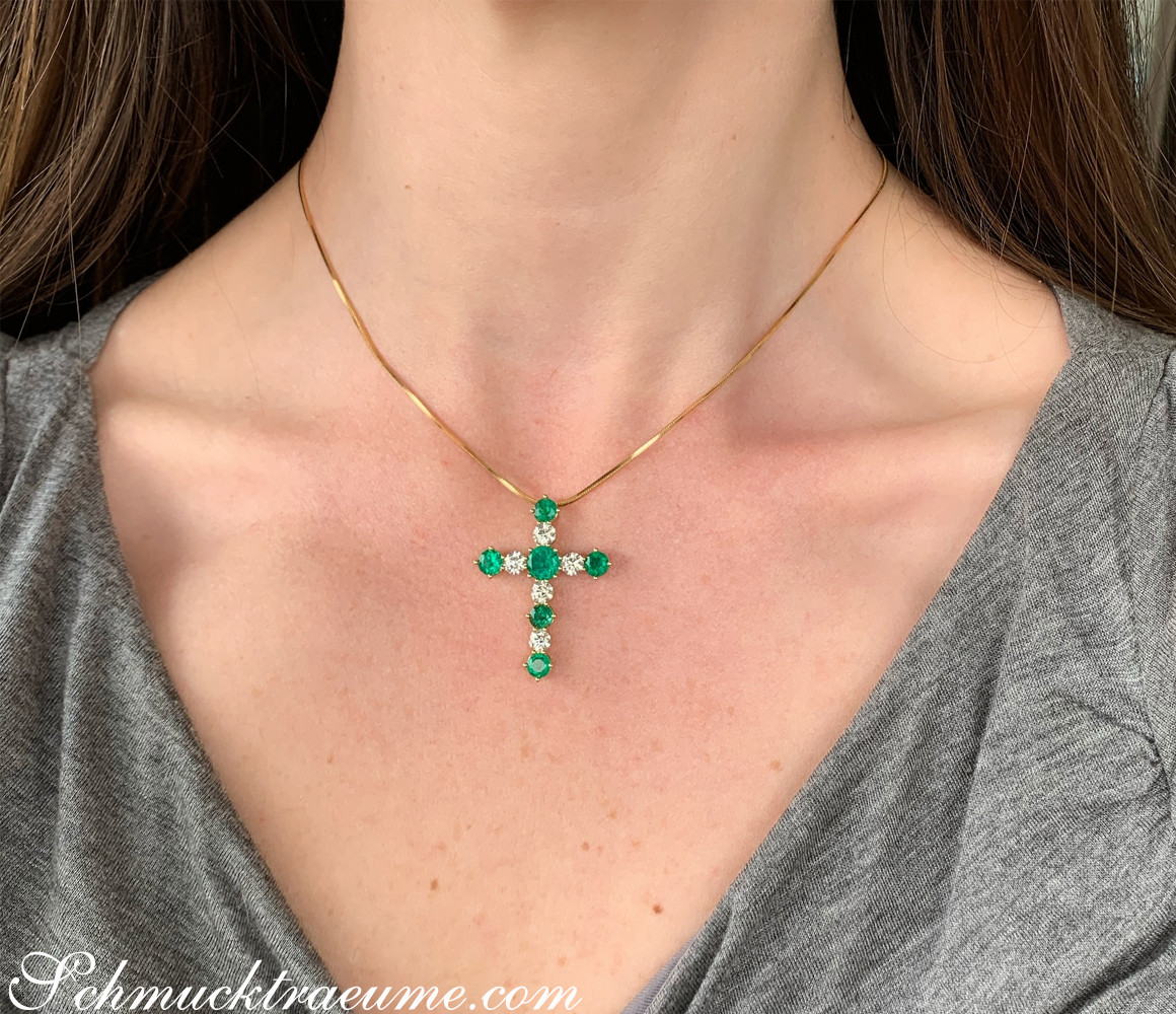 Goldener Kreuzanhänger mit Smaragden und Brillanten getragen.