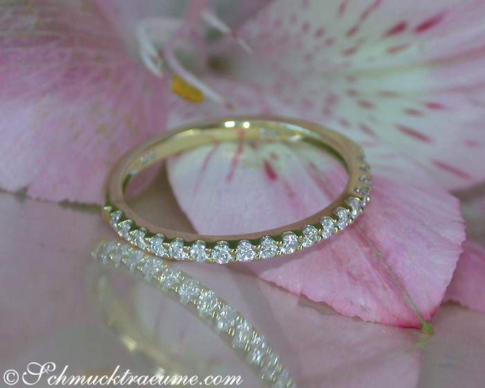 Goldener Diamant-Ring mit feinen Strasssteinen, Detailaufnahme auf rosa Blüte.