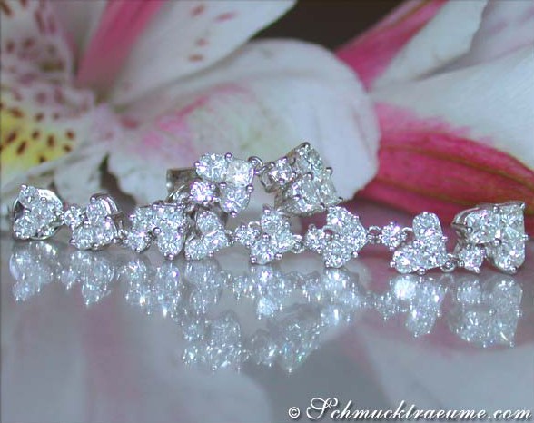 Detailansicht von Diamant-Ohrgehängen im Herz-Design auf weißem Hintergrund.