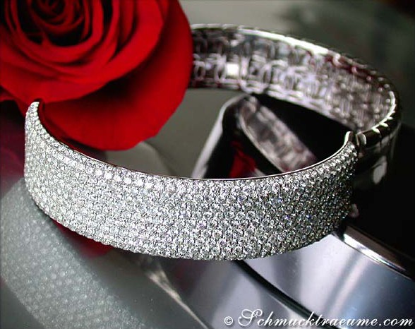 Weißgold-Armreif mit 11 ct. Brillanten, Detailaufnahme, rote Rose im Hintergrund