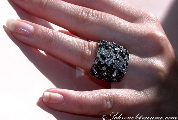 Schwarz-weiß-diamantener Ring auf Hand mit Nagelkunst