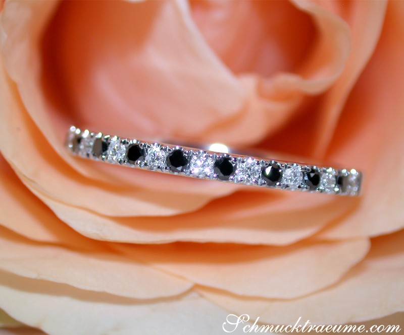 Halb Memoryring aus Weißgold mit schwarzen und weißen Diamanten auf Rosenblüte.