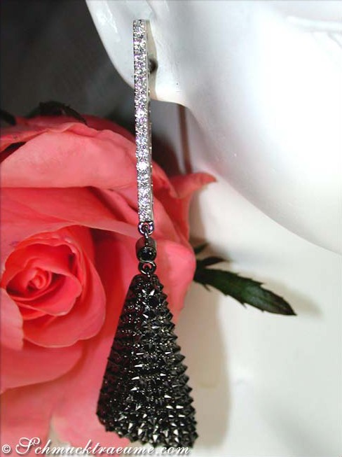 Schwarze Diamant-Ohrhänger mit weißem Gold, Rosenblüte im Hintergrund