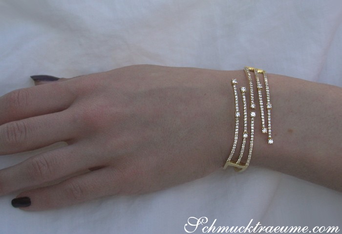 Edler Goldarmreif mit Diamanten auf weißem Hintergrund