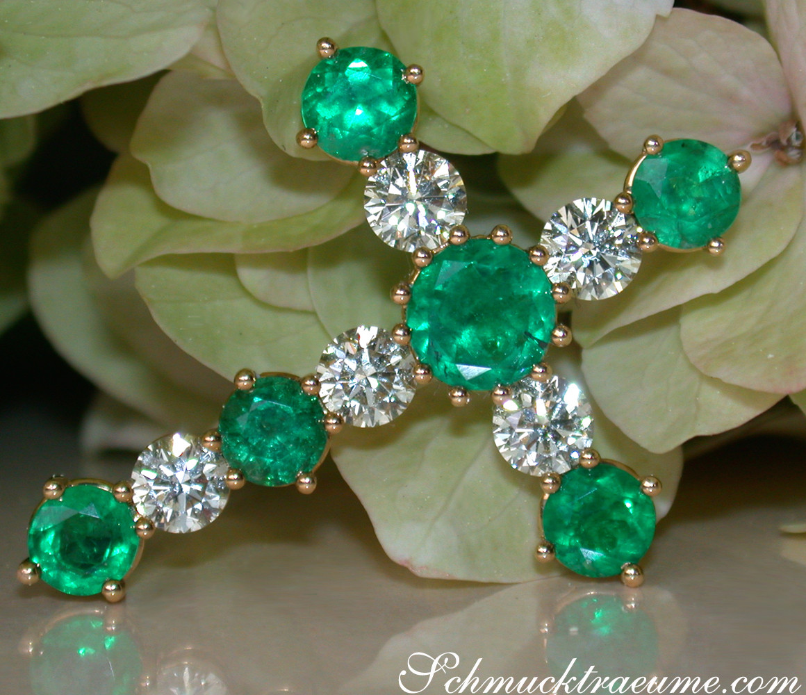 Goldener Kreuzanhänger mit Smaragden und Diamanten, Detailaufnahme, Blütenhintergrund