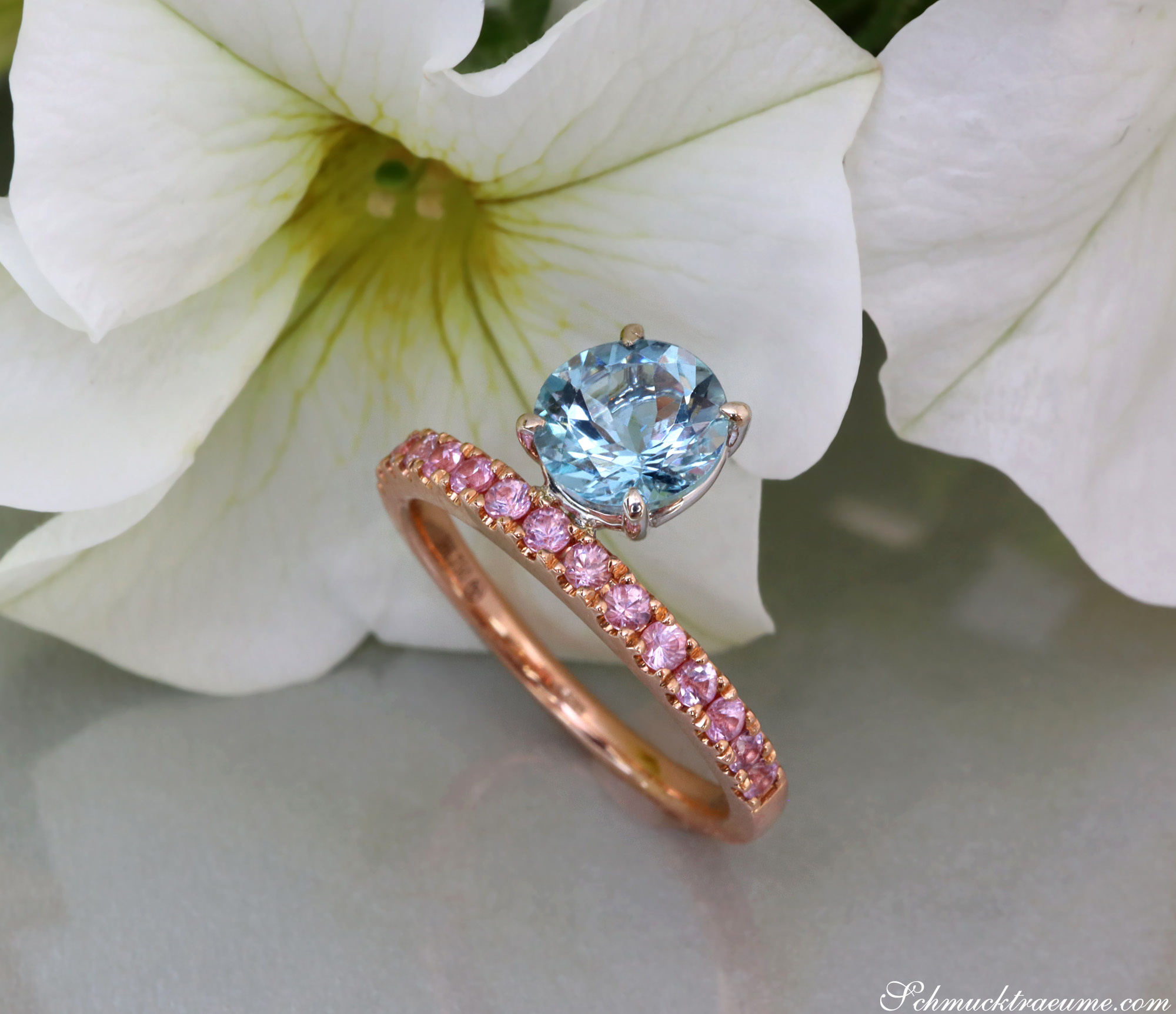 Blauer Aquamarin-Ring mit rosa Saphiren, detailreiches Design, vor Blüte gezeigt