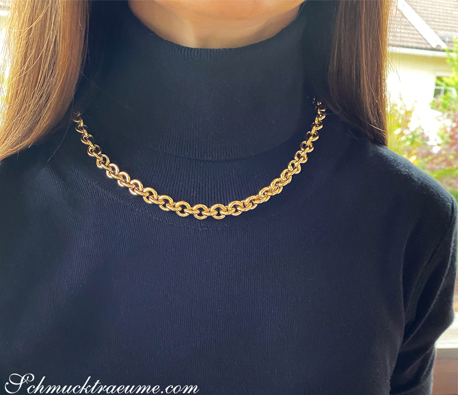 Goldene Gliederkette aus Gelbgold 585, Detailaufnahme auf schwarzem Hals, leicht verspielter Look.