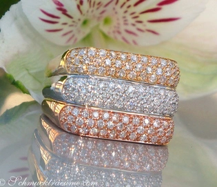 Tricolor Diamanterringe auf glänzender Oberfläche, Hintergrund Blume