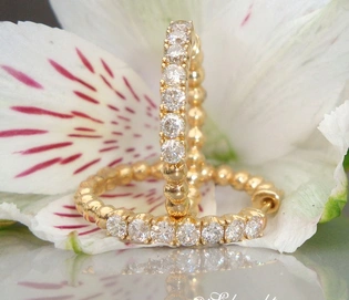 Goldene Creolen mit Diamanten auf Blüte