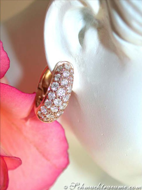 Feine Brillanten Creolen in Roségold 585, Detailaufnahme mit rosafarbenem Blütenblatt im Hintergrund