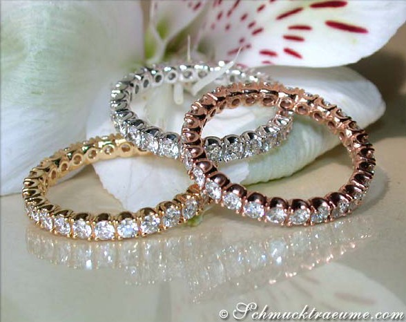 Erhabene Brillanten-Memory-Ringe in Weiß-, Rosé- & Gelbgold 585, elegant auf Blütenblättern gestellt