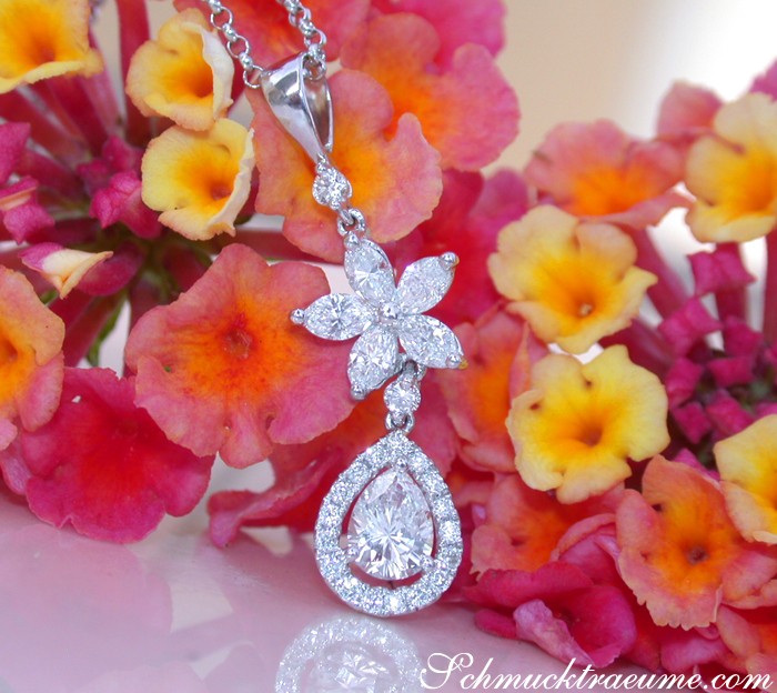 Diamant-Tropfen-Anhänger mit Marquise-Diamanten in Weißgold, detailreich, vor Blütenhintergrund.