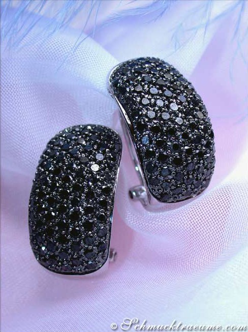 Detailansicht der eleganten schwarzen Diamant-Ohrstecker auf weichem Stoff