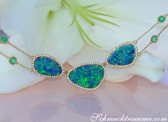 Gelbgold-Collier mit Boulder Opalen, Smaragden und Brillanten auf Blume liegend