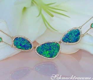 Gelbgold-Collier mit Boulder Opalen, Smaragden und Brillanten auf Blume liegend