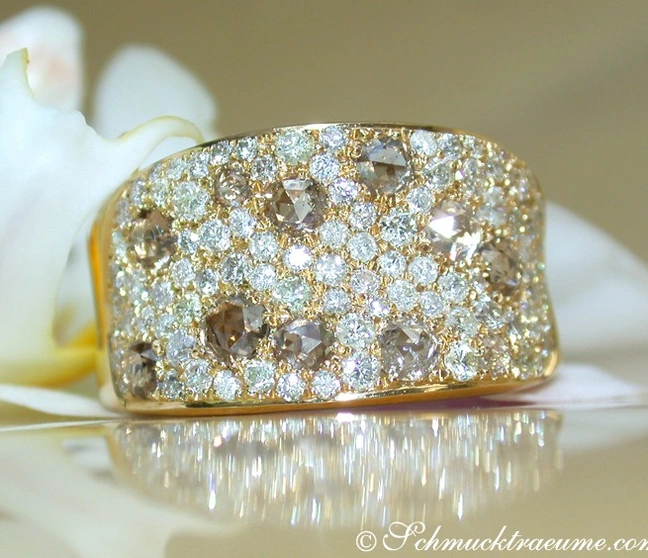 Goldener Brillant-Ring mit Diamanten und Brauntönen, Detailaufnahme, elegant auf Blüte platziert. Goldener Brillant-Ring mit Diamanten und Brauntönen, Detailaufnahme, elegant auf Blüte platziert.