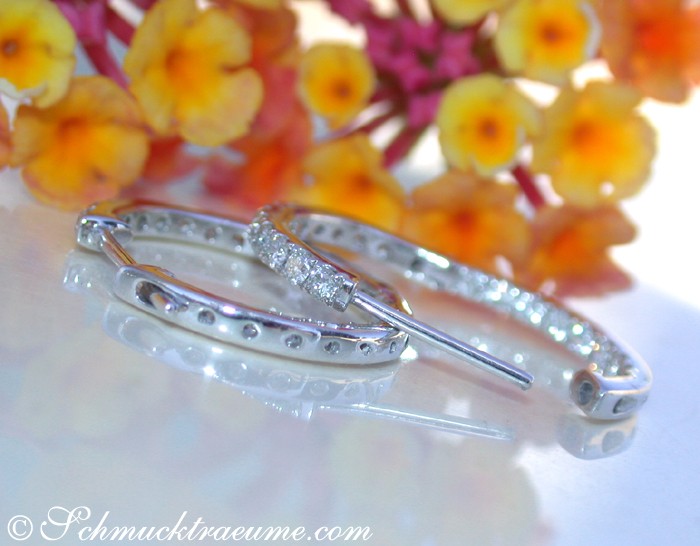 Weißgold-Creolen mit Brillanten, Detailaufnahme, 1,9 cm Ø, Blumen im Hintergrund