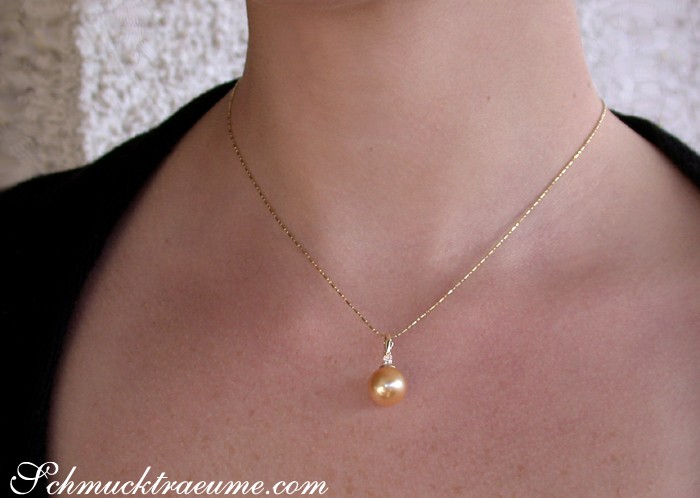 Goldene Südseeperle-Anhänger mit Brillant auf zarter Kette getragen