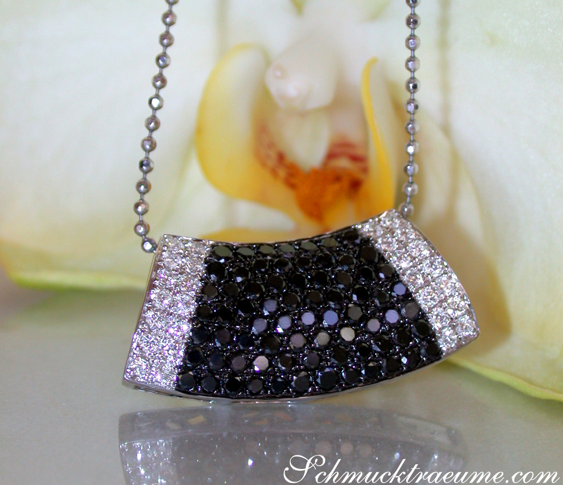 Schwarz-weiß-Diamant-Anhänger mit klaren Linien und Weißgold 585, Detailaufnahme vor Orchidee.