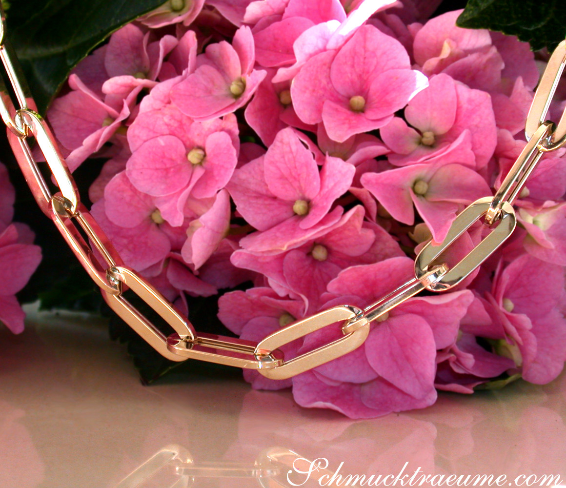 Goldene Paperclip-Halskette auf rosa Hortensienblüten